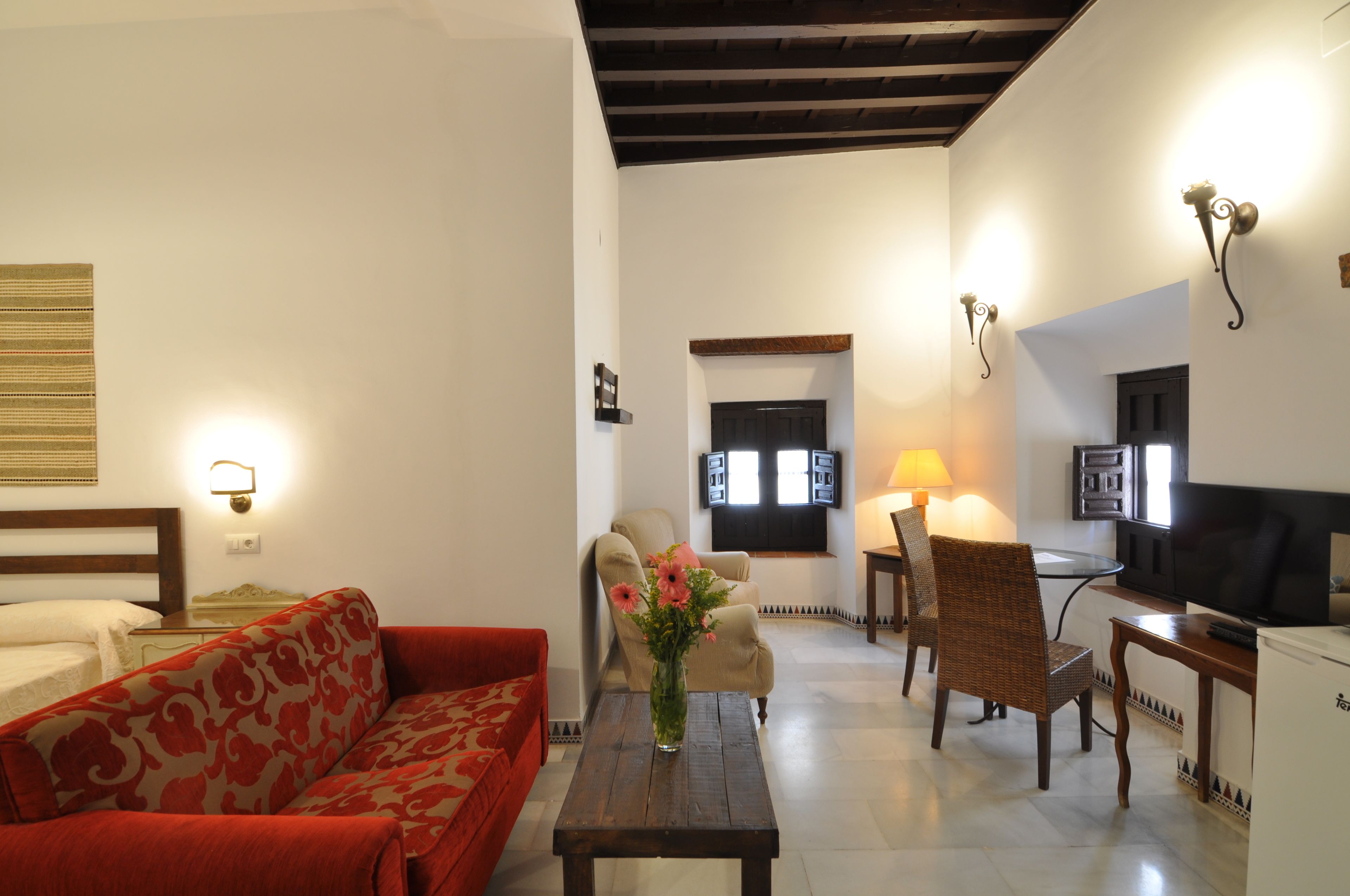 Una sala de estar con un sofá, una mesa de centro, un televisor y una lámpara.