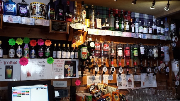 A bar with various liquor bottles and a computer monitor. - Star Hotel (Montrose)