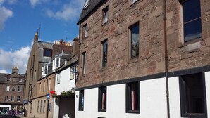 A row of traditional brick buildings with white facades, multiple windows, and a clear blue sky. - Star Hotel (Montrose)