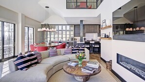 Una sala de estar moderna con un sofá curvo, una mesa de centro y una chimenea.