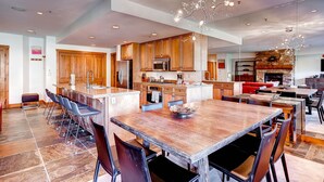 A spacious kitchen with wooden cabinets, a large island, and a modern chandelier. - Luxury 4bdr Ski In-out /premium Amenities 4 Bedroom Condo by RedAwning (Keystone)