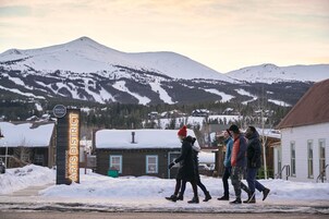 A snowy outdoor scene with a sign for Breckenridge Arts District.