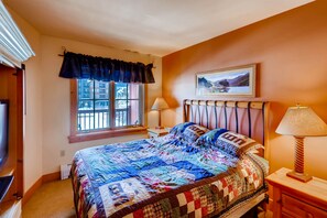 Cozy retreat with a large bed, bedside table, and window.