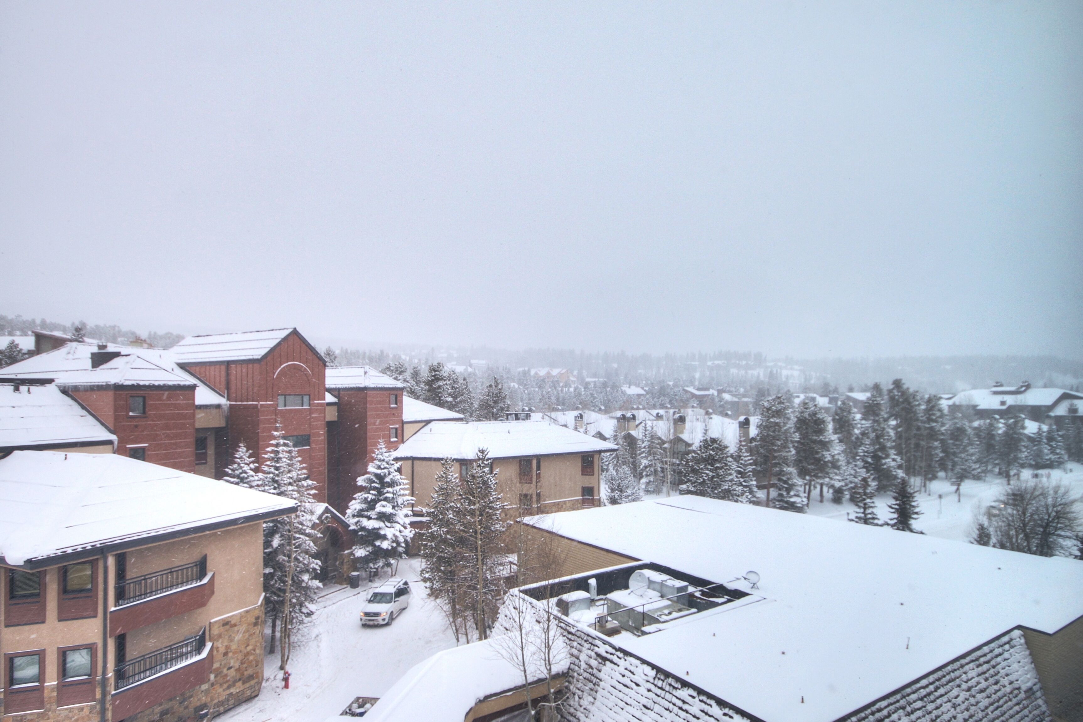 Ett bostadsområde med snötäckta byggnader och träd.
