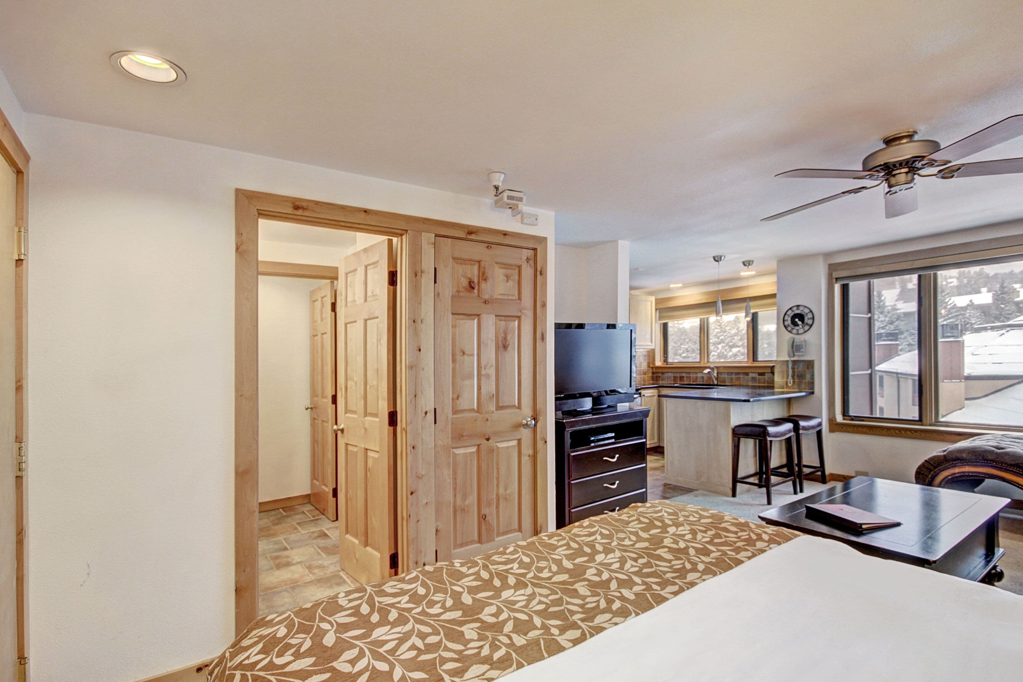 Une chambre d’hôtel équipée d’un lit, d’un bureau, d’une télévision et d’une kitchenette.