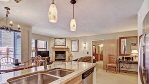 A spacious kitchen with granite countertops, stainless steel appliances, and pendant lighting.