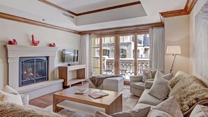 A spacious living room with a fireplace, a television, and comfortable seating.