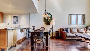 A spacious living area with a dining table, chairs, a sofa, and a large window. - 2 BR Condo at The Lodge at Vail View of Gore Range by RedAwning - Save 20% on 7+ Nights! (Vail)