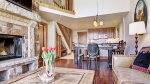 A spacious living area with a fireplace, a dining table, and a kitchen in the background. - 2 BR Condo at The Lodge at Vail View of Gore Range by RedAwning - Save 20% on 7+ Nights! (Vail)