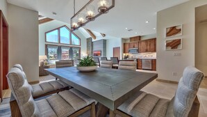 A spacious kitchen with wooden cabinets, a large island, and a dining area with a table and chairs.