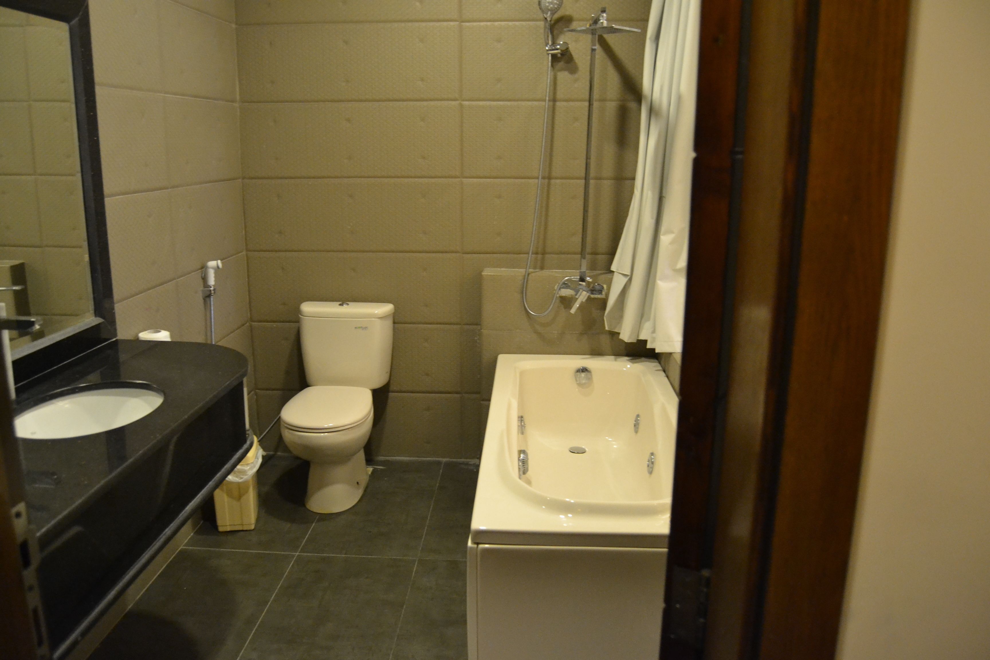 A bathroom with a black sink, white toilet, and a bathtub.