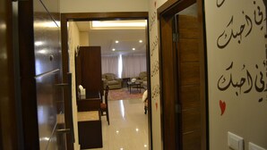 Un pasillo que conduce a una sala de estar con un sofá y una mesa de centro.