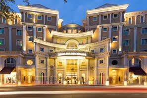 Fachada imponente de un hotel con arquitectura clásica, ventanas amplias y una entrada destacada.