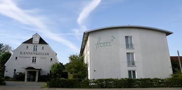 Um edifício com uma placa que diz 'KANNENKELLER RESTAURANT HOTEL'.