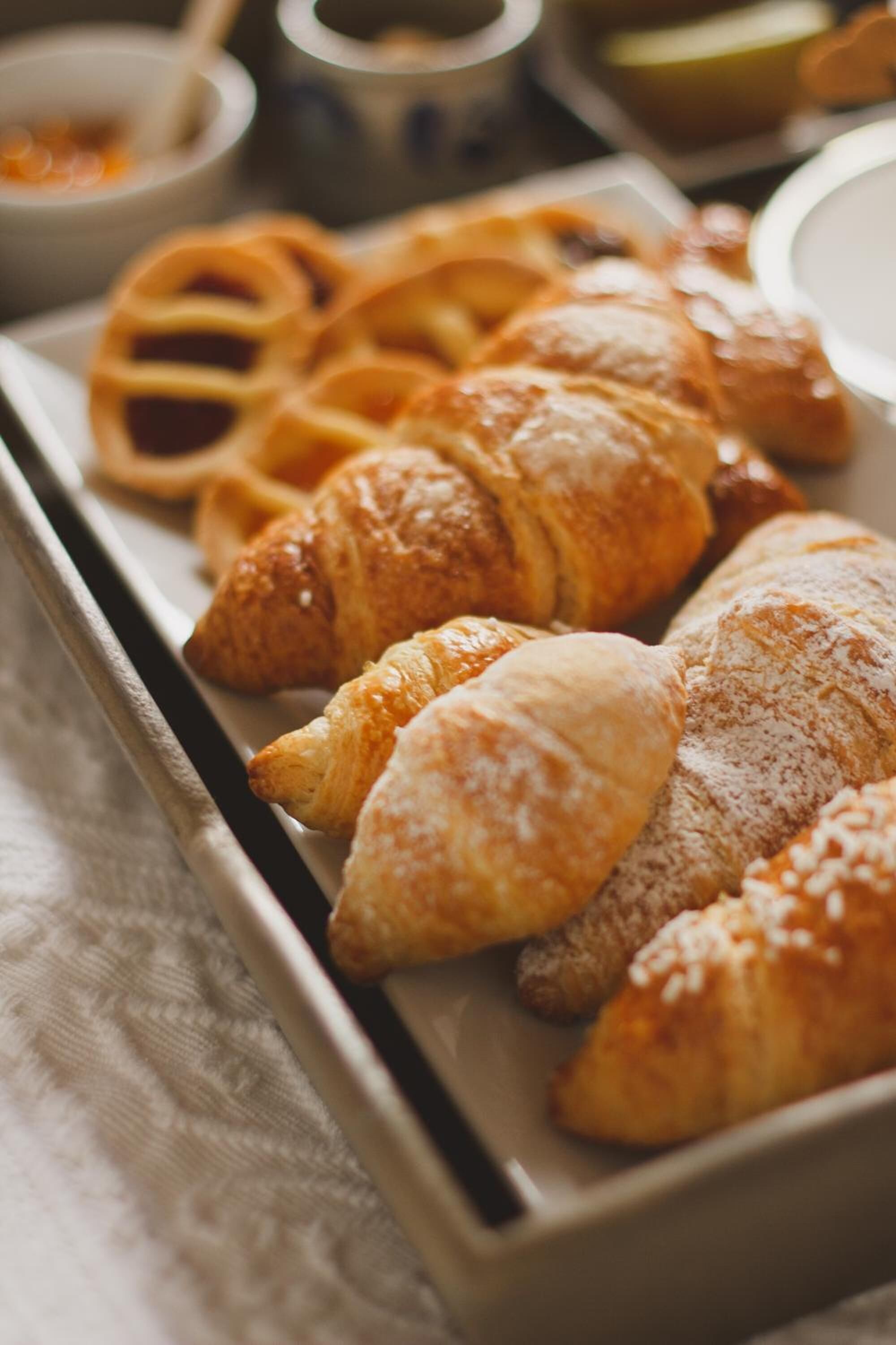 A tray with various pastries including croissants and waffles.