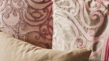 Un sofá color beige con tres almohadones decorativos.