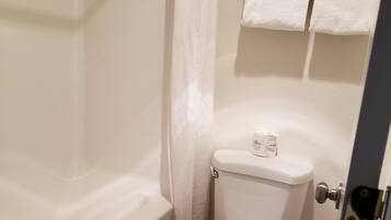 Un baño con bañera, inodoro y cortina de ducha.