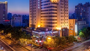 Ein Hochhaus-Hotel mit mehreren Stockwerken, auffälliger Beschilderung und einer gut beleuchteten Fassade.