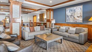 A spacious living area with two sofas, a coffee table, and a patterned rug.