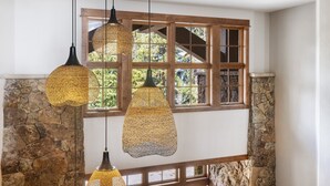 A room with stone walls, wooden beams, and a large window with multiple panes.