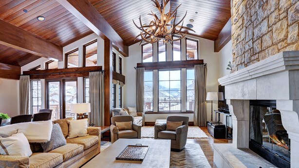 A spacious living room with a fireplace, large windows, and a high ceiling. - Luxury Mountainside 5BR Chalet in Vail Village by RedAwning (Vail)