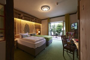 Una habitación de hotel con cama, escritorio, silla y televisor.