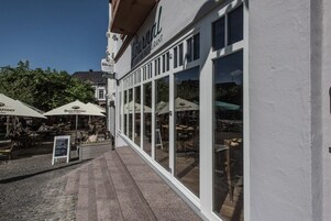 Un café bar restaurante con terraza y sombrillas.