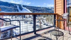 Un balcone con vista su una montagna innevata e un parcheggio.
