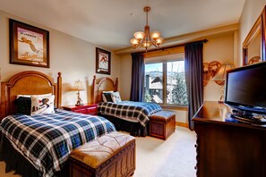 A bedroom with two beds, a TV, and a window with curtains. - 5br/5ba , Ski In/out In Arrowhead, 3523 Sq Ft! 5 Bedroom Condo by RedAwning (Edwards)