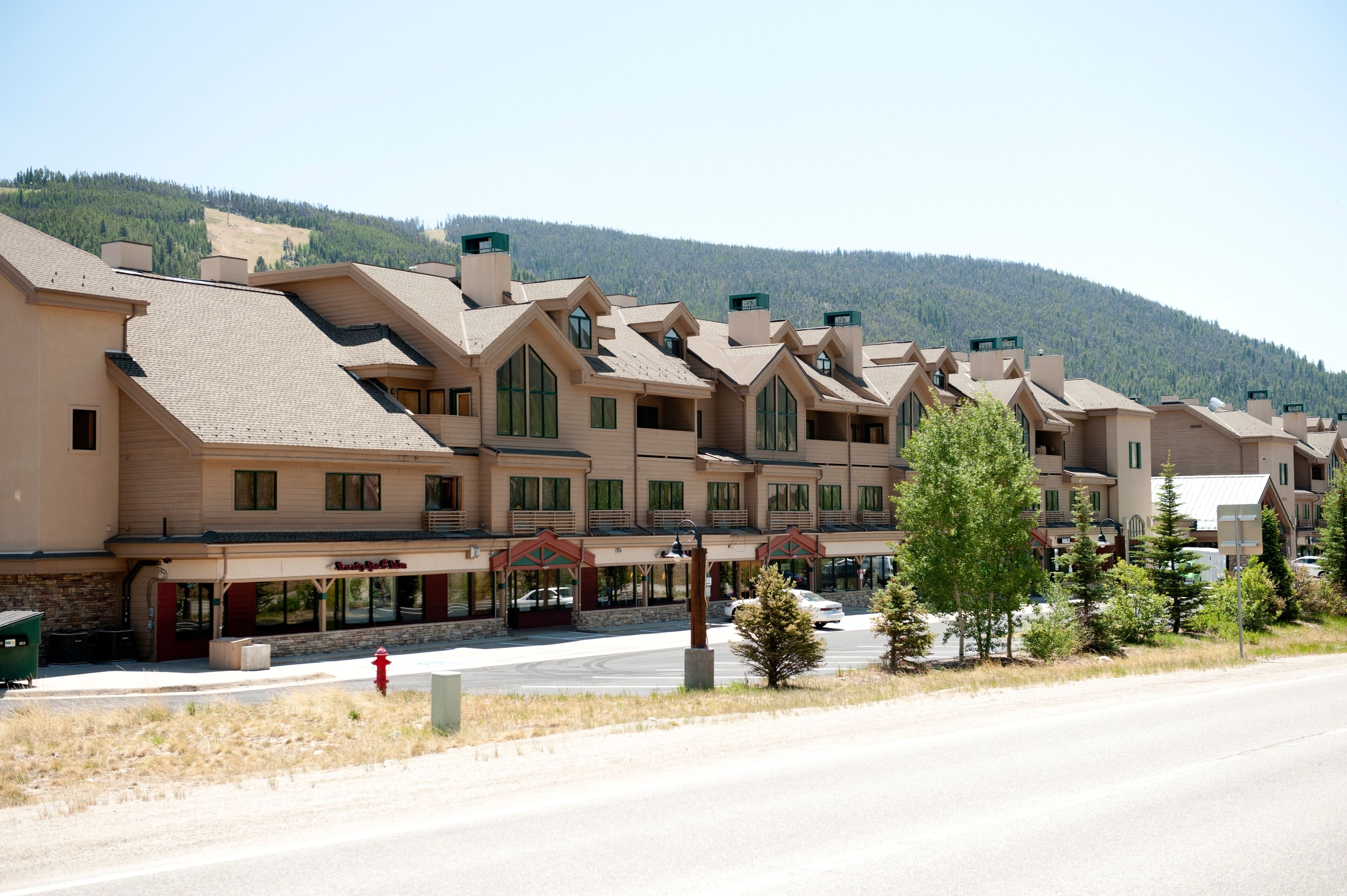 A row of multi-story buildings with a consistent architectural style, featuring large windows and a flat roof.
