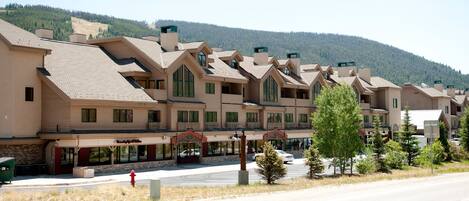 A row of multi-story buildings with a consistent architectural style, featuring large windows and a flat roof.