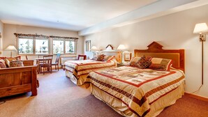 A cozy bedroom with two beds, a wooden headboard, a desk, and a chair. - Gateway 5070 (Keystone)