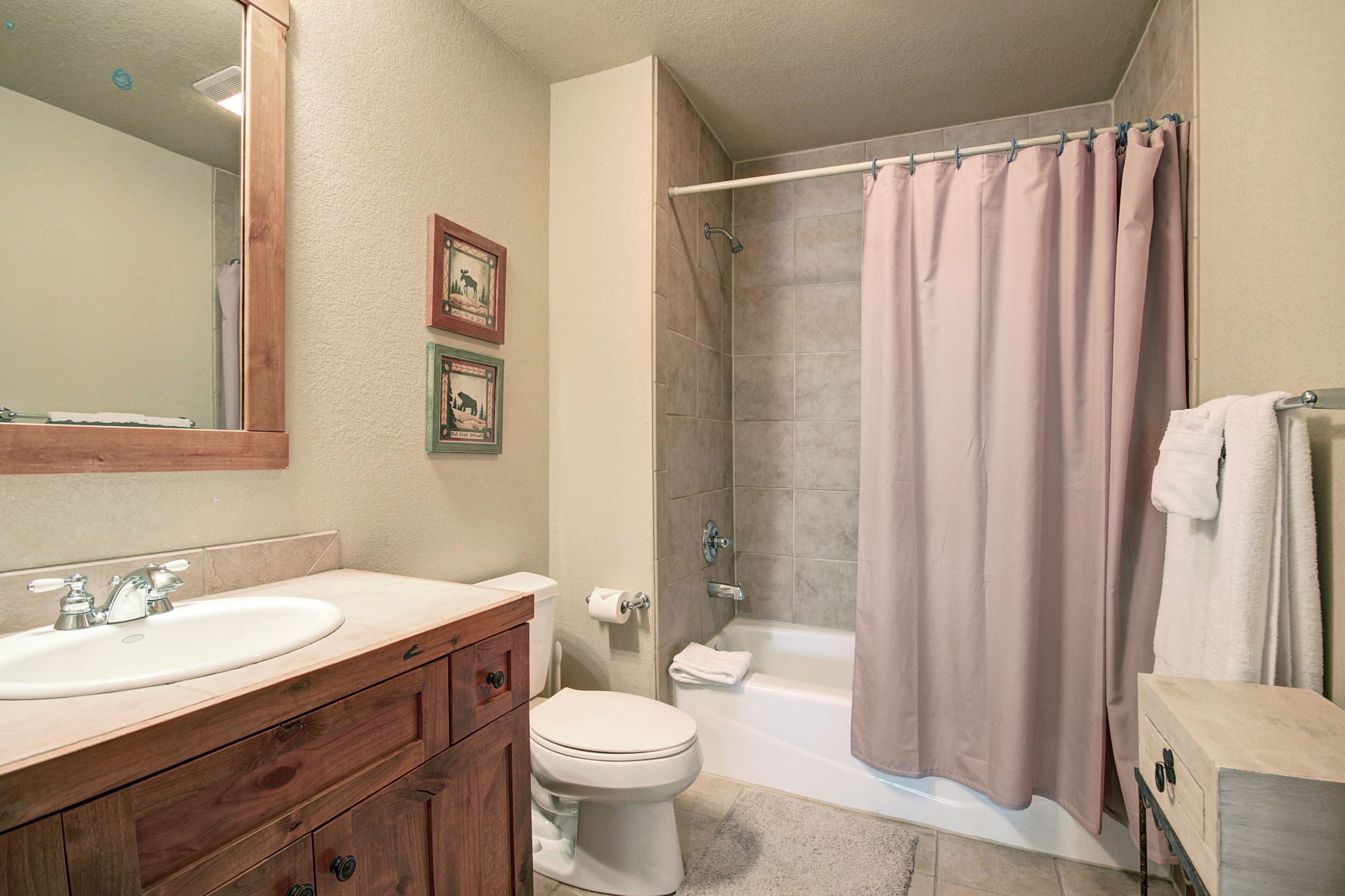 A bathroom with a sink, toilet, shower, and bathtub.
