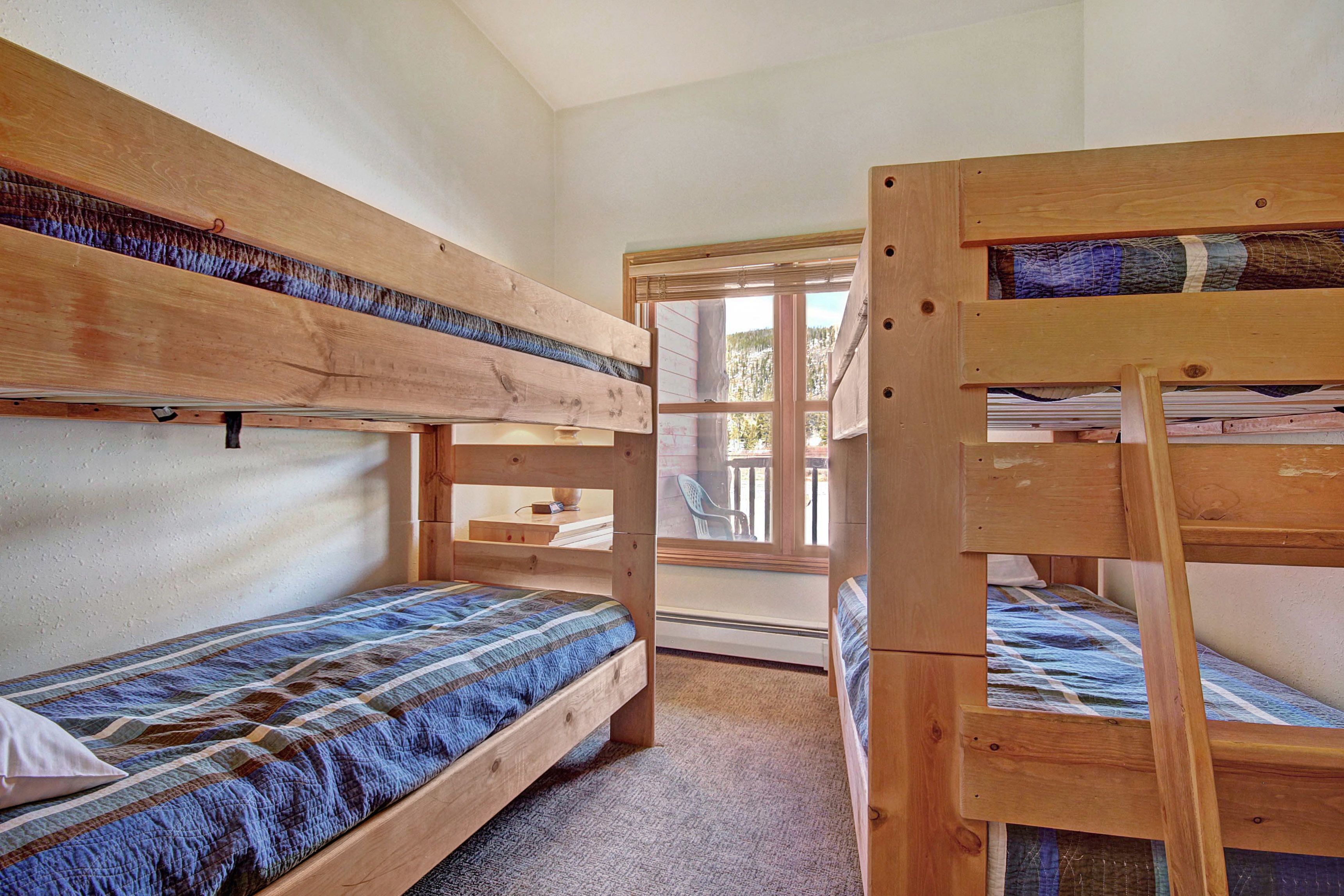Une chambre avec un lit superposé et une fenêtre donnant sur l’extérieur.