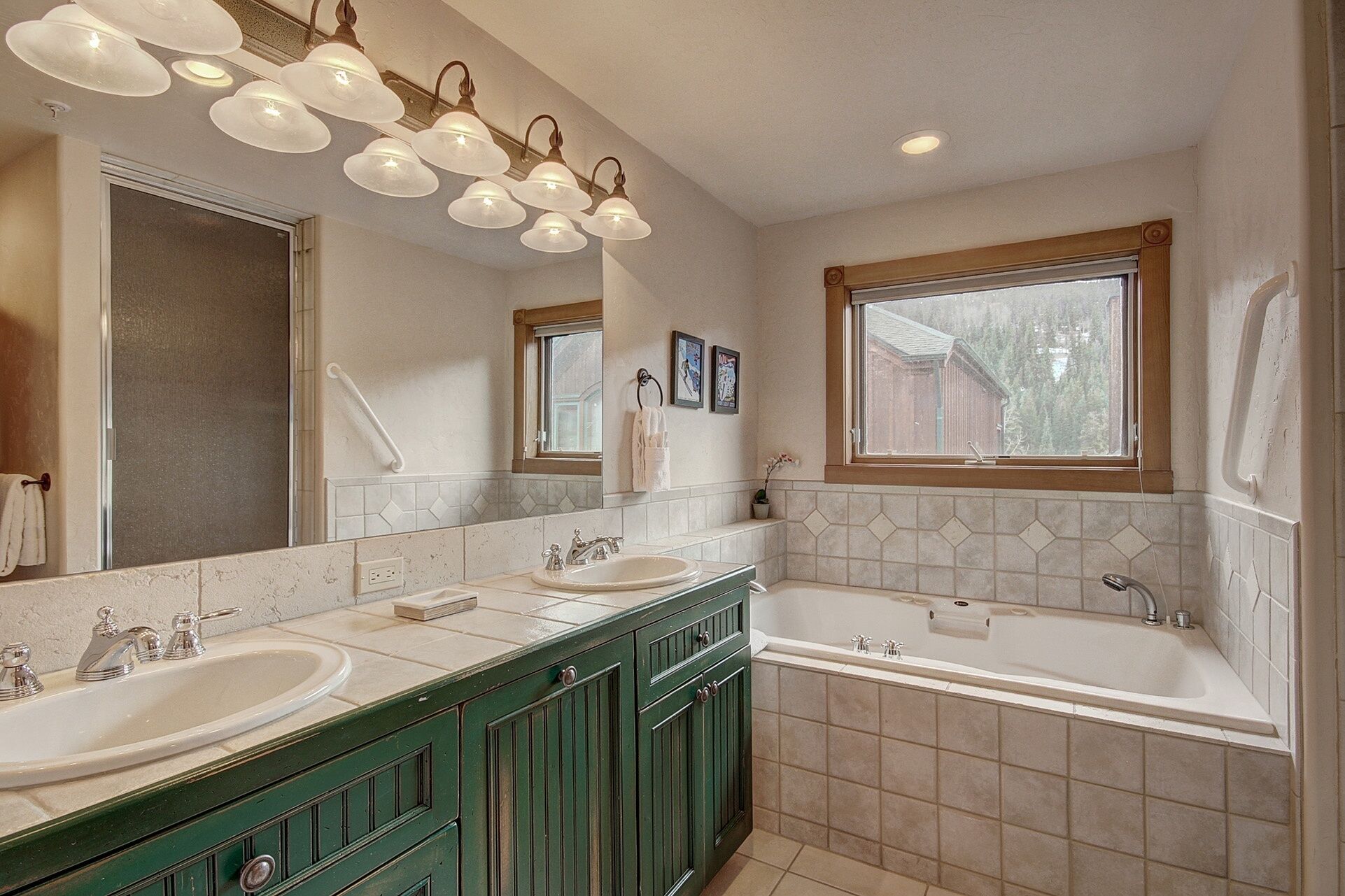 A bathroom with two sinks, a bathtub, and a window.