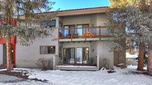 A two-story house with a balcony, large windows, and a covered entryway. - 1125 Flying Dutchman 1 Bedroom Condo by RedAwning (Keystone)