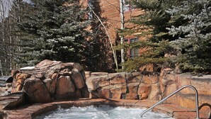 A hot tub surrounded by rocky terrain and trees. - 8824 The Springs 2 Bedroom Condo by RedAwning (Keystone)