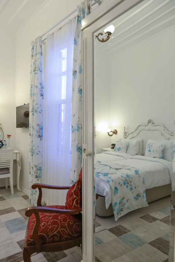A bedroom with a bed, a chair, a nightstand, and a mirror. - Dantela Butik Hotel (Cesme)