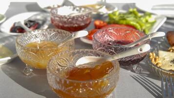 A table with various food items including bowls of fruit preserves and a salad.