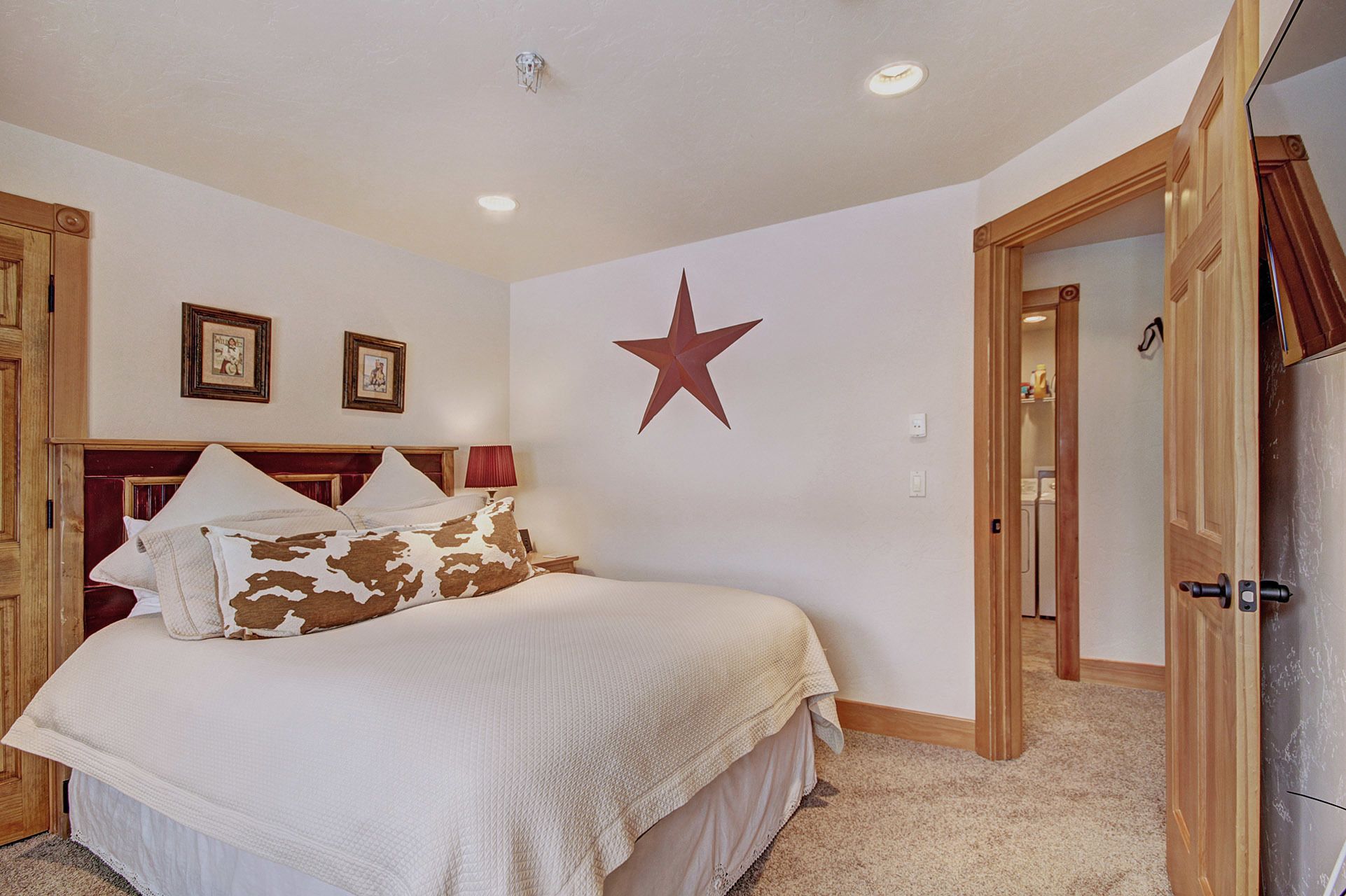 A bedroom with a bed, a star decoration, and wooden doors.