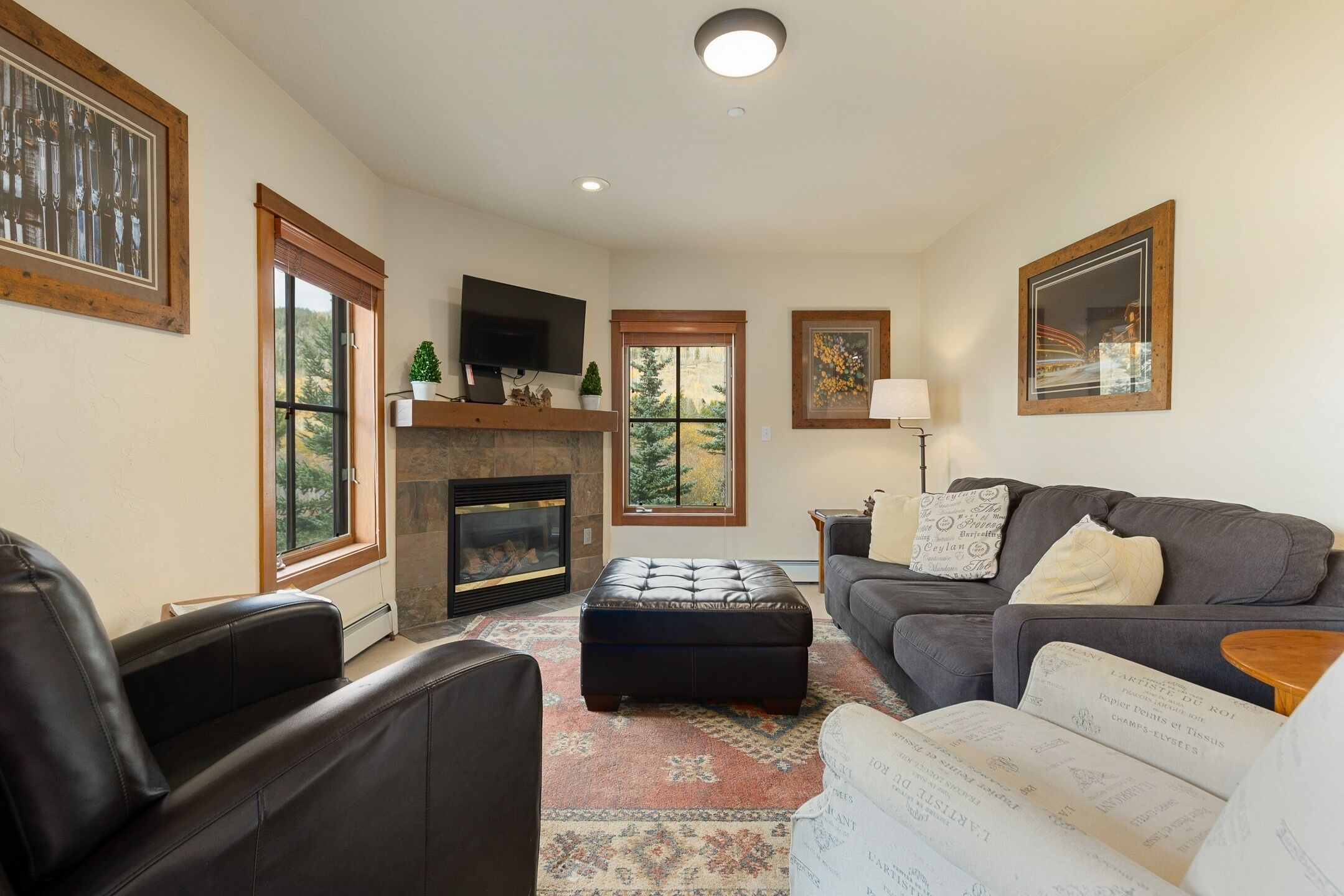 A living room with a fireplace, a sofa, a coffee table, and a television.