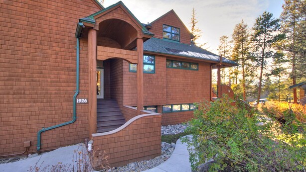 A brick house with a porch, a number '1926' on the wall, and a stone pathway leading to the entrance. - 1926 Soda Springs Ii 3 Bedroom Townhouse by RedAwning (Keystone)