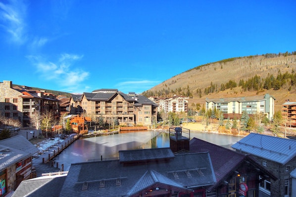 A resort with multiple buildings, a central courtyard, and a lake.