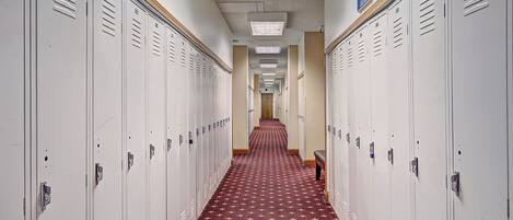A long hallway with lockers on both sides and a patterned carpet.