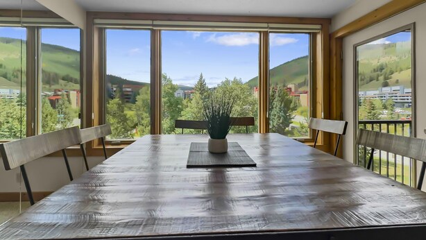 Un coin repas avec une grande table, des chaises et une plante en pot.