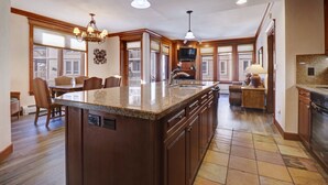 A spacious kitchen with a large island, wooden cabinetry, and a built-in oven.