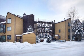 A building with a metal staircase and a sign reading "Anaconda." Snow covers the ground and trees. - Beautiful Dog Friendly Ski Chalet A Minute to SuperBee Lift - AN203 by RedAwning (Copper Mountain)