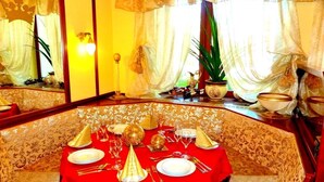 A dining area with a red tablecloth, gold accents, and a patterned wall. - Hotel Krone (Alsfeld)