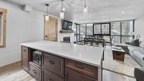 A modern kitchen with a large island, wooden cabinets, and pendant lighting. - Amazing Location - Steps to American Eagle Lift - CJ202 by RedAwning (Copper Mountain)