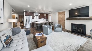 A modern living room with a sofa, coffee table, and a fireplace. - Amazing Location - Steps to American Eagle Lift - CJ202 by RedAwning (Copper Mountain)